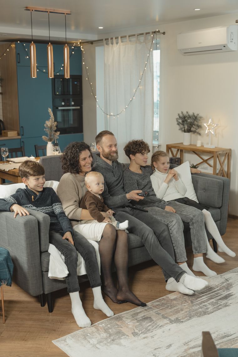 Família reunida assistindo TV na sala