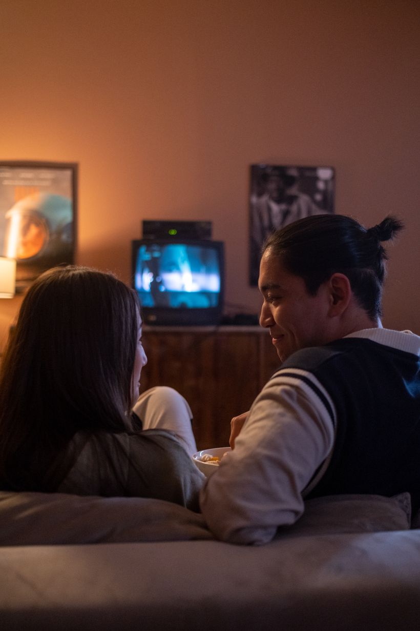 Pessoas assistindo a um filme na TV da sala